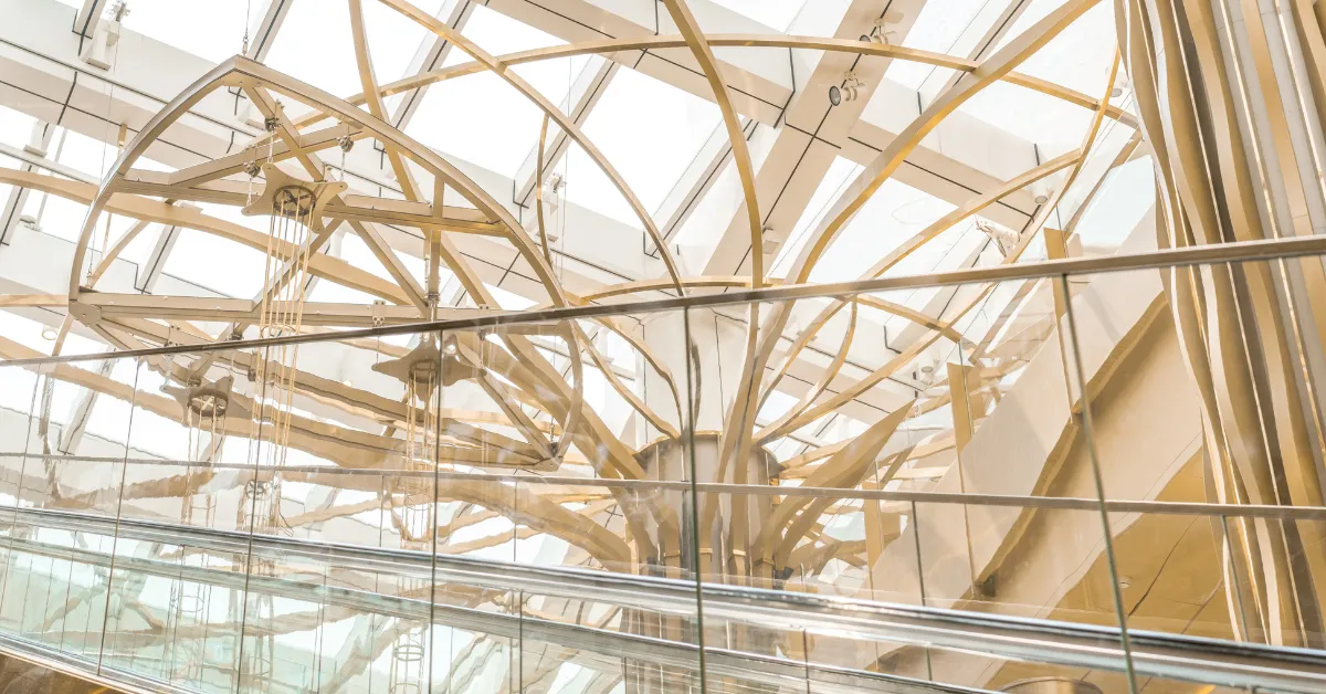 Modern architectural interior with glass, steel beams, and a skylit atrium.