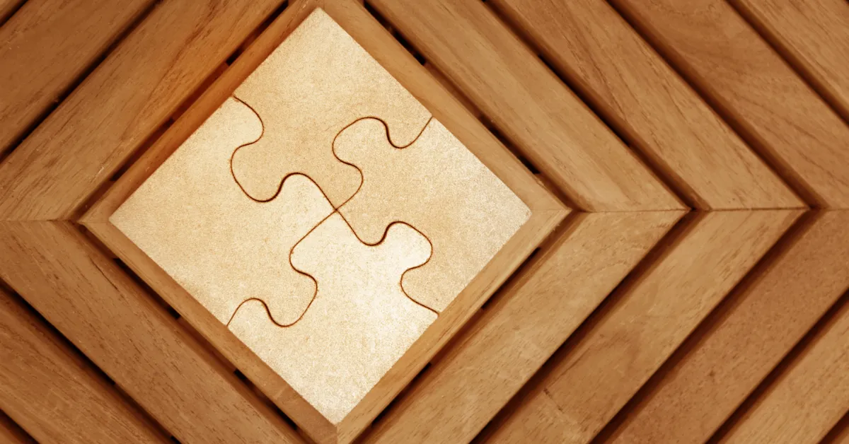 Close-up of interlocking puzzle pieces set within a geometric wooden frame.